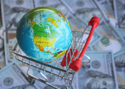 Globe in a trolley against a background of cash